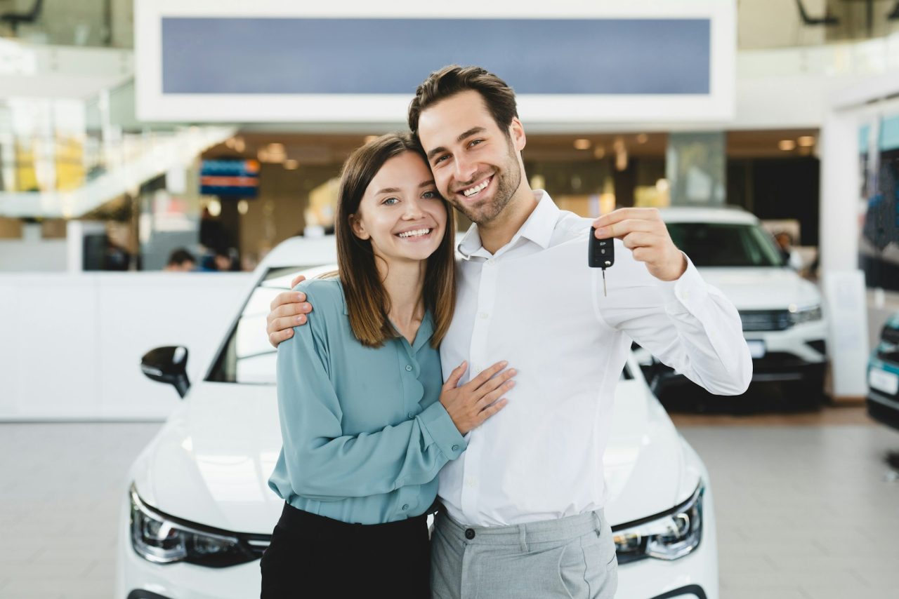 family-holding-car-keys-after-buying-new-automobile-at-dealer-shop-store-.jpg